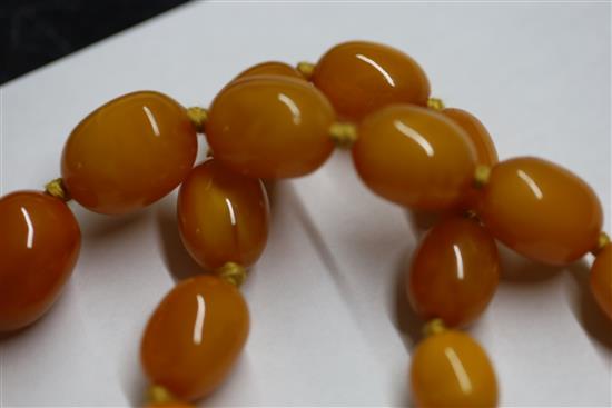 A single strand graduated oval amber bead necklace, 97cm.